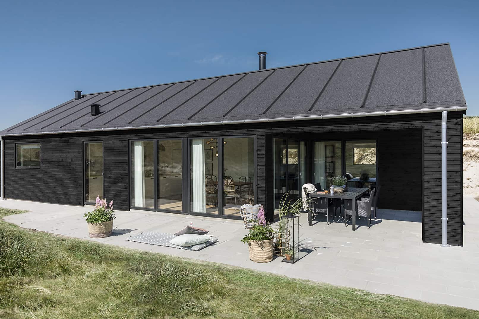 Sommerhus i træ med tagpap og terrasse