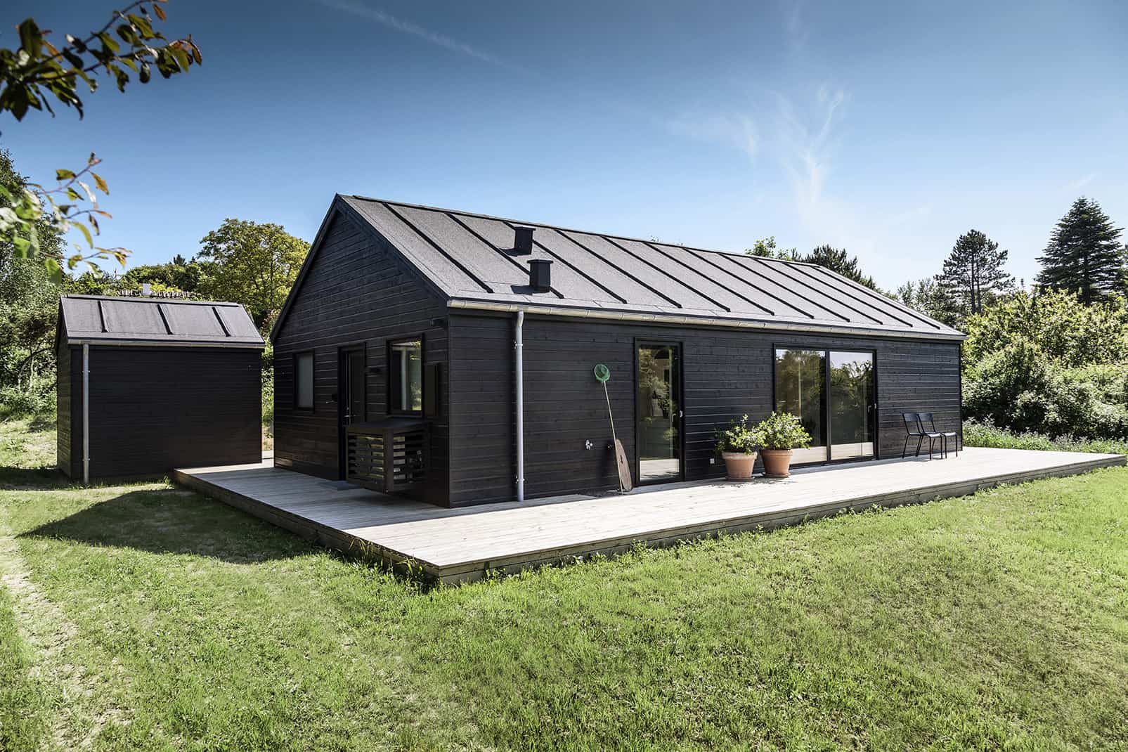 Arkitekttegnet sommerhus i sort set udefra