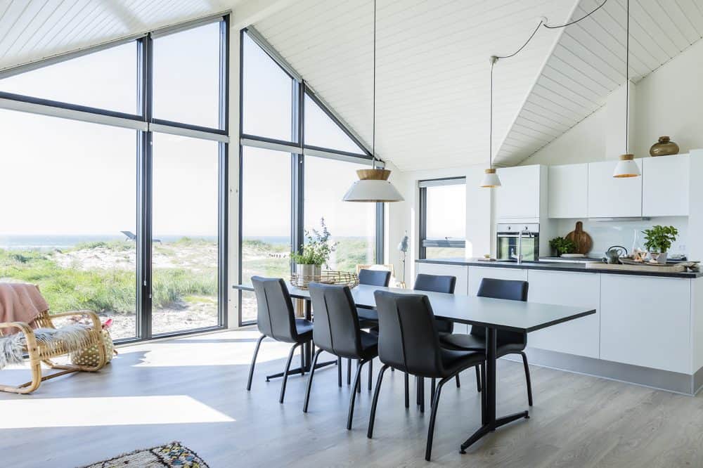 Køkken og spisebord i sommerhus med stort vinduesparti