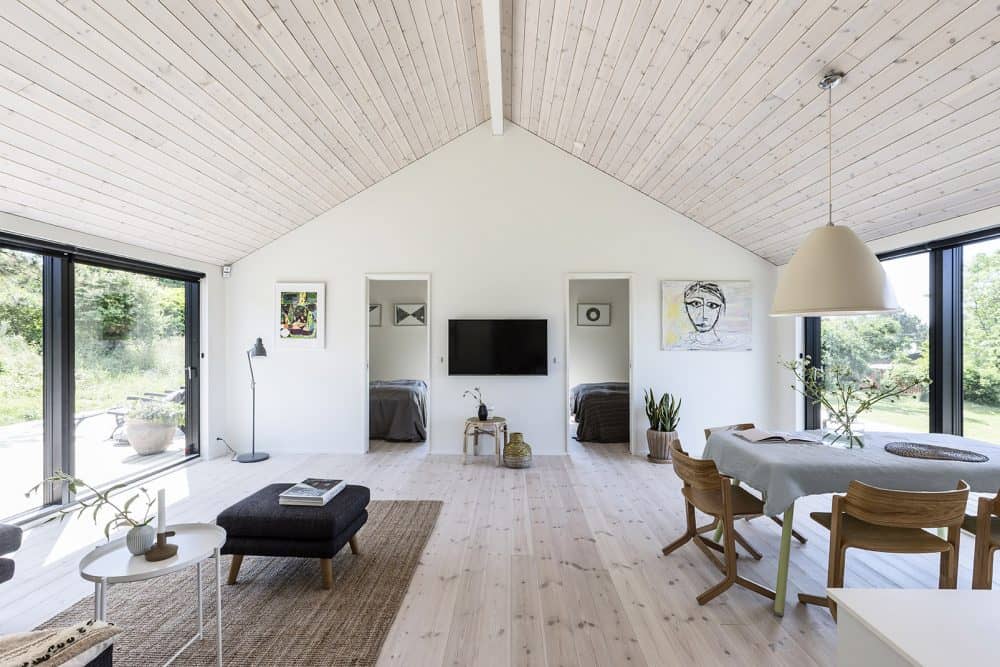 Lyst opholdsrum med trælofter i sommerhus