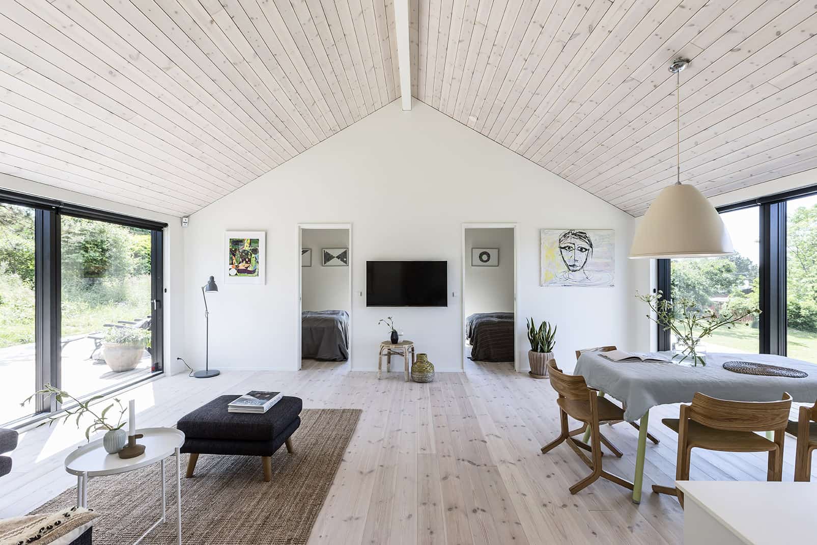 Lyst opholdsrum med trælofter i sommerhus