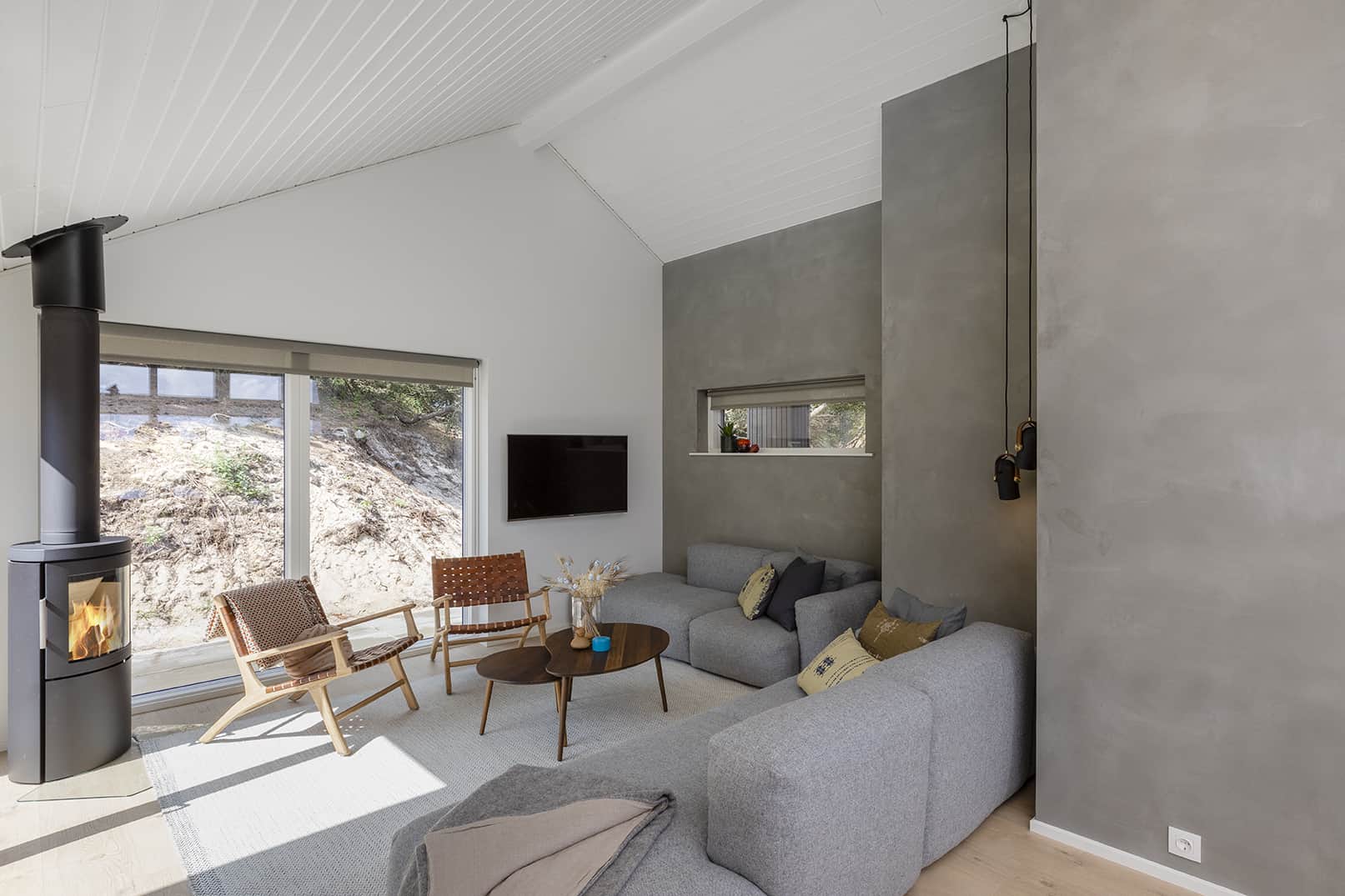 Skanlux sommerhus med rå, rå vægge og brændeovn i stue