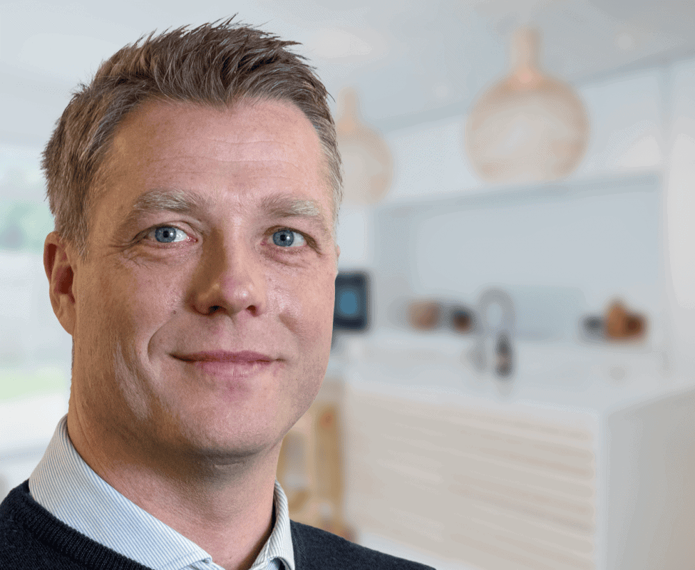 Kristian Petersen portrætfoto med køkkenbaggrund