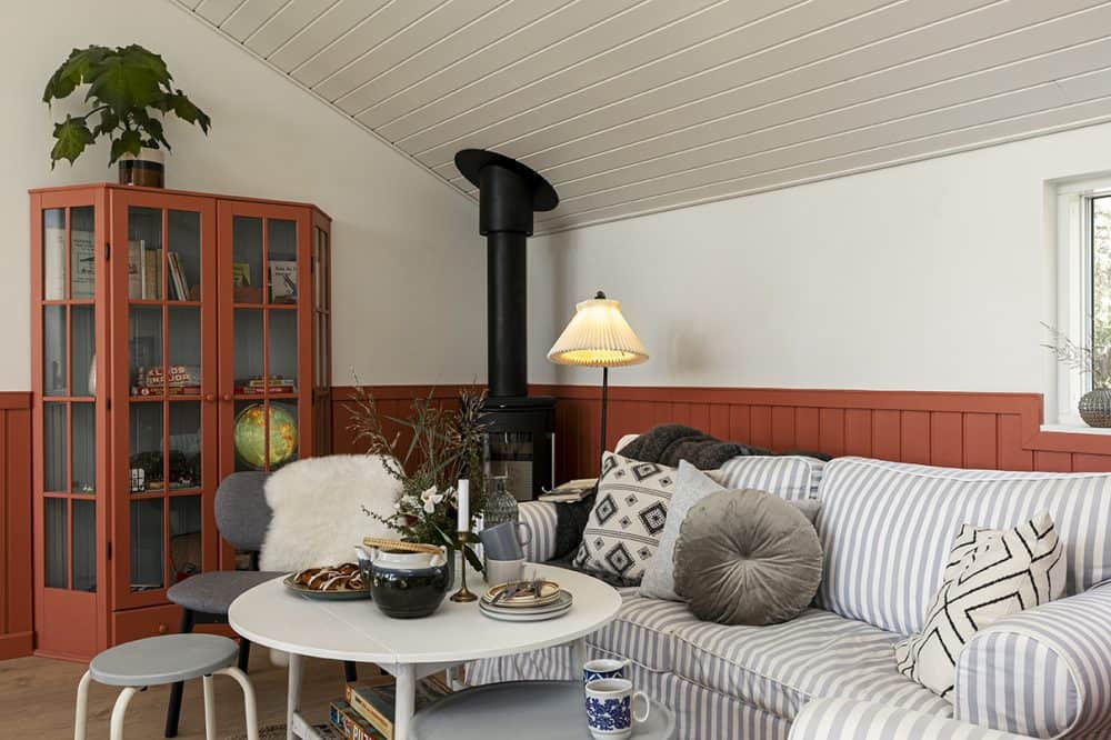 Hyggekrog i sommerhus med sofa og brændeovn