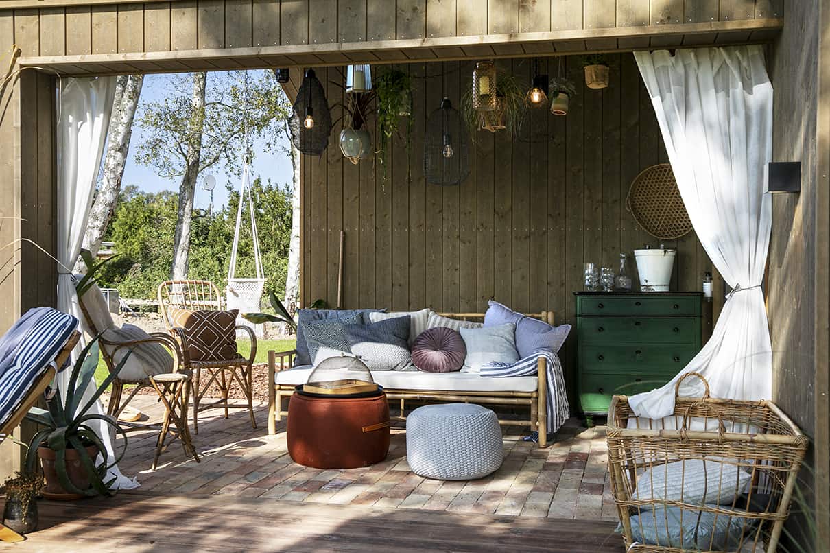 Overdækket terrasse i sommerhus med hyggelig indretning