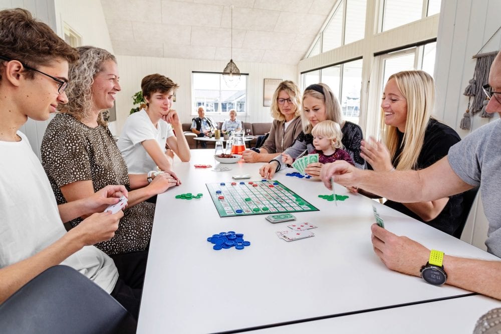 Familie spiller brætspil i Skanlux sommerhus