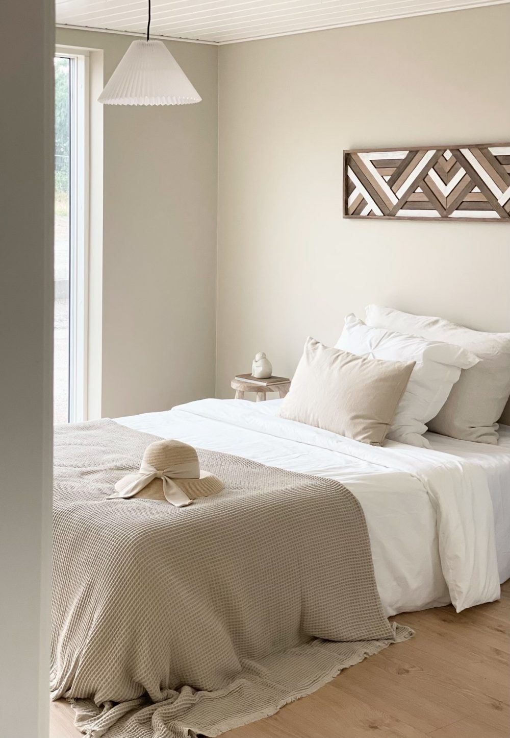 Soveværelse i moderne farver med trægulv og dobbeltseng