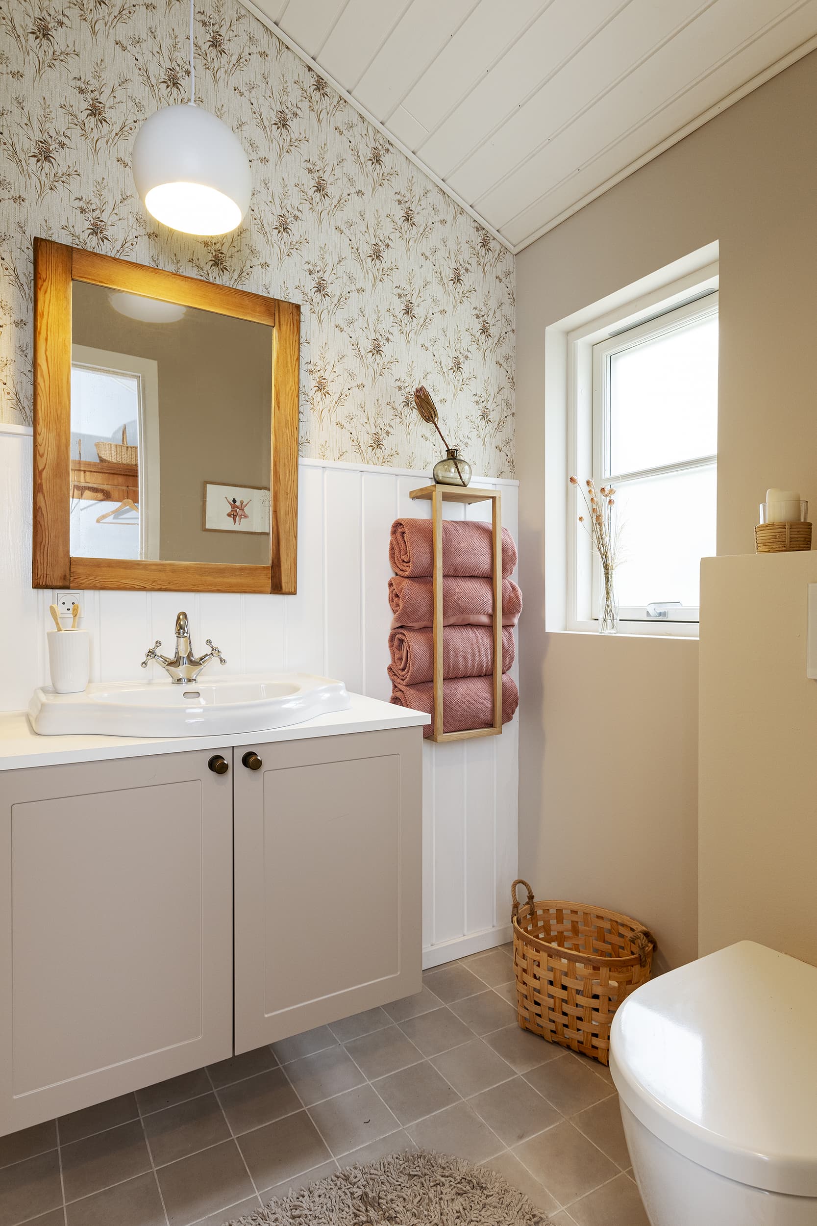 Lyst og hyggeligt sommerdrømme badeværelse - indrettet med blomstertapet, tørrede blomster og dæmpede farver på væggene