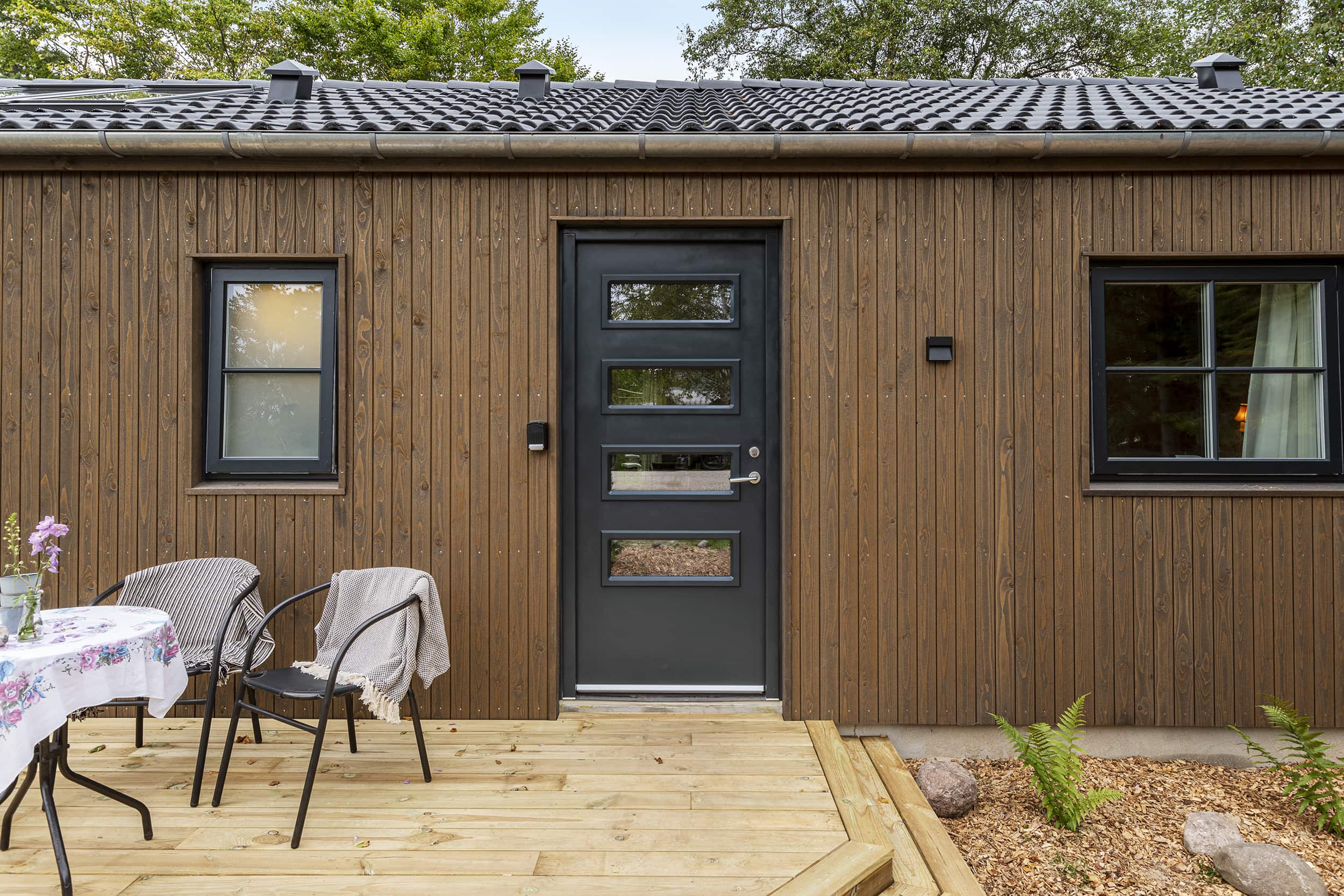 Louise og Nicolajs hyggelige forhave med veranda fra TV2 Sommerdrømme 2022. Arkitekttegnet Skanlux sommerhus