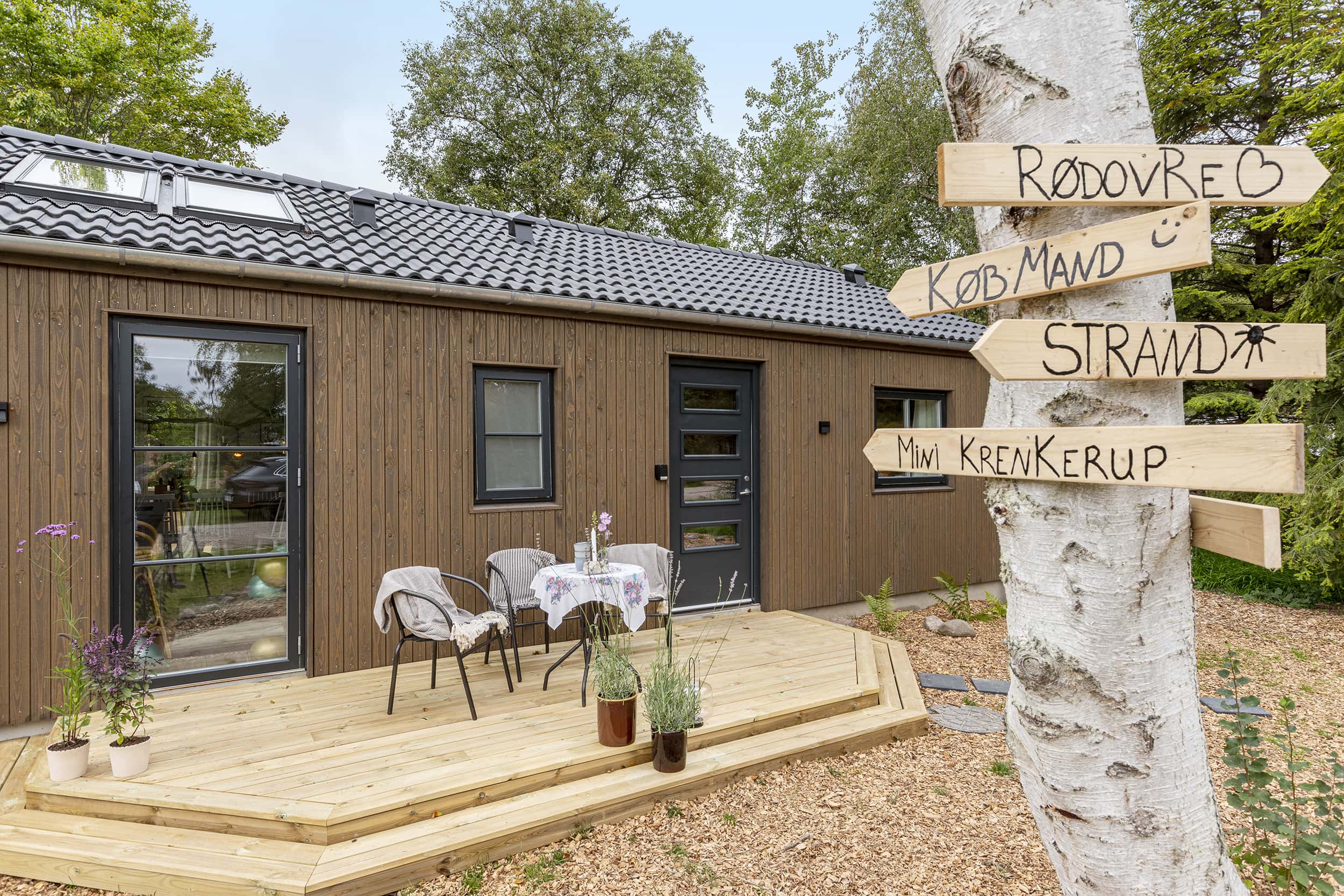 Louise og Nicolajs hyggelige forhave med veranda fra TV2 Sommerdrømme 2022. Arkitekttegnet Skanlux sommerhus