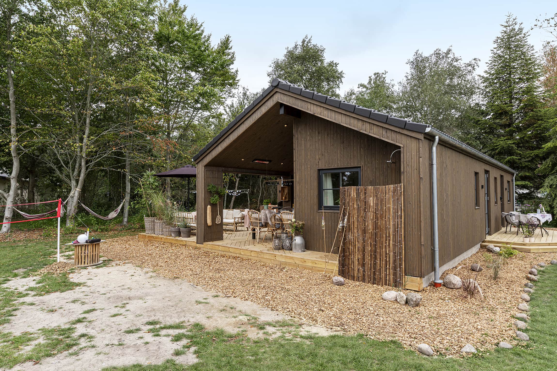 Louise og Nicolajs hyggelige have fra TV2 Sommerdrømme 2022 med udebruser. Arkitekttegnet Skanlux sommerhus