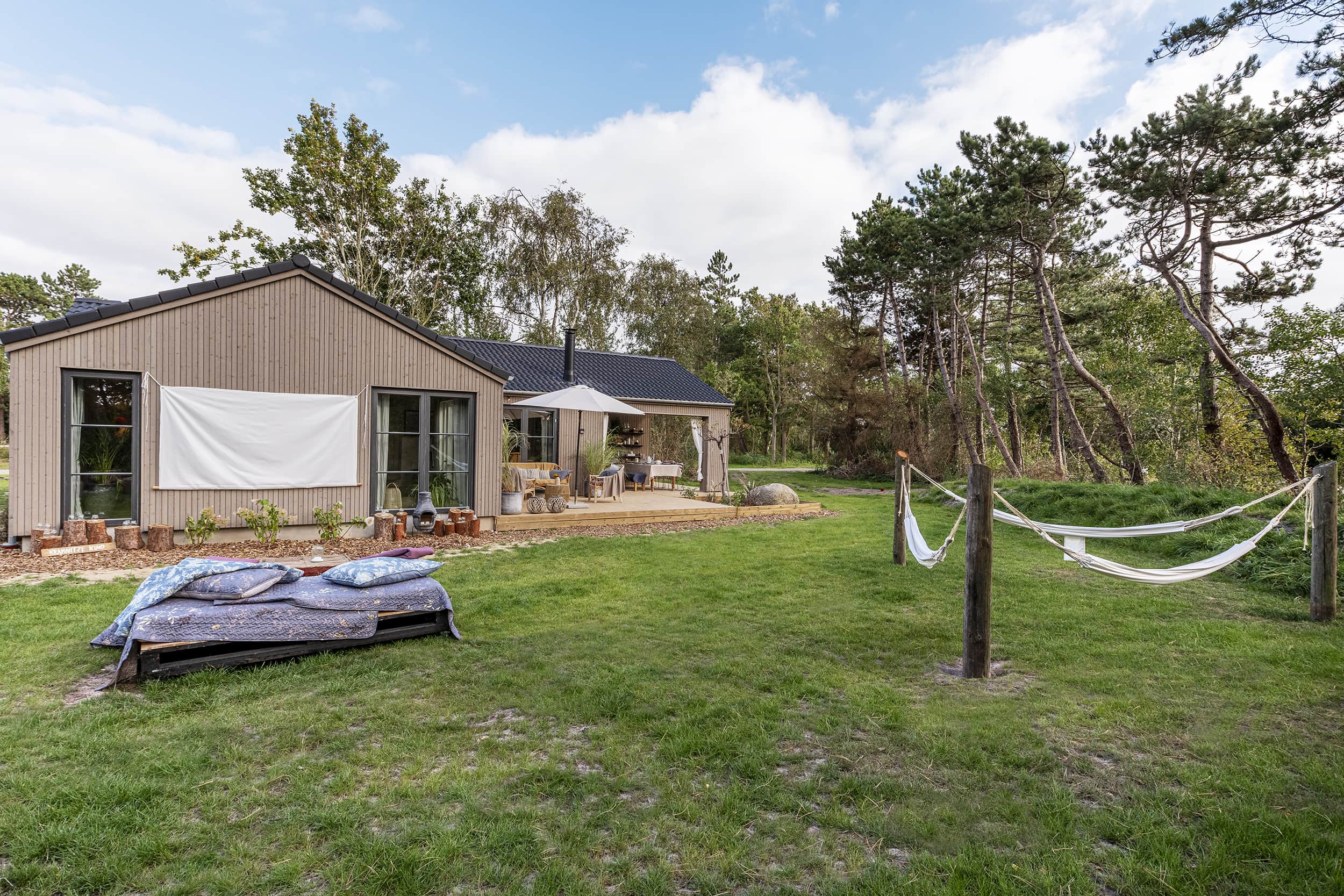 Anja og Marcus kreative uderum og have fra TV2 Sommerdrømme 2022 med udendørs biograf. og hængekøjer Sommerhuset er fra Skanlux Byggefirma A/S