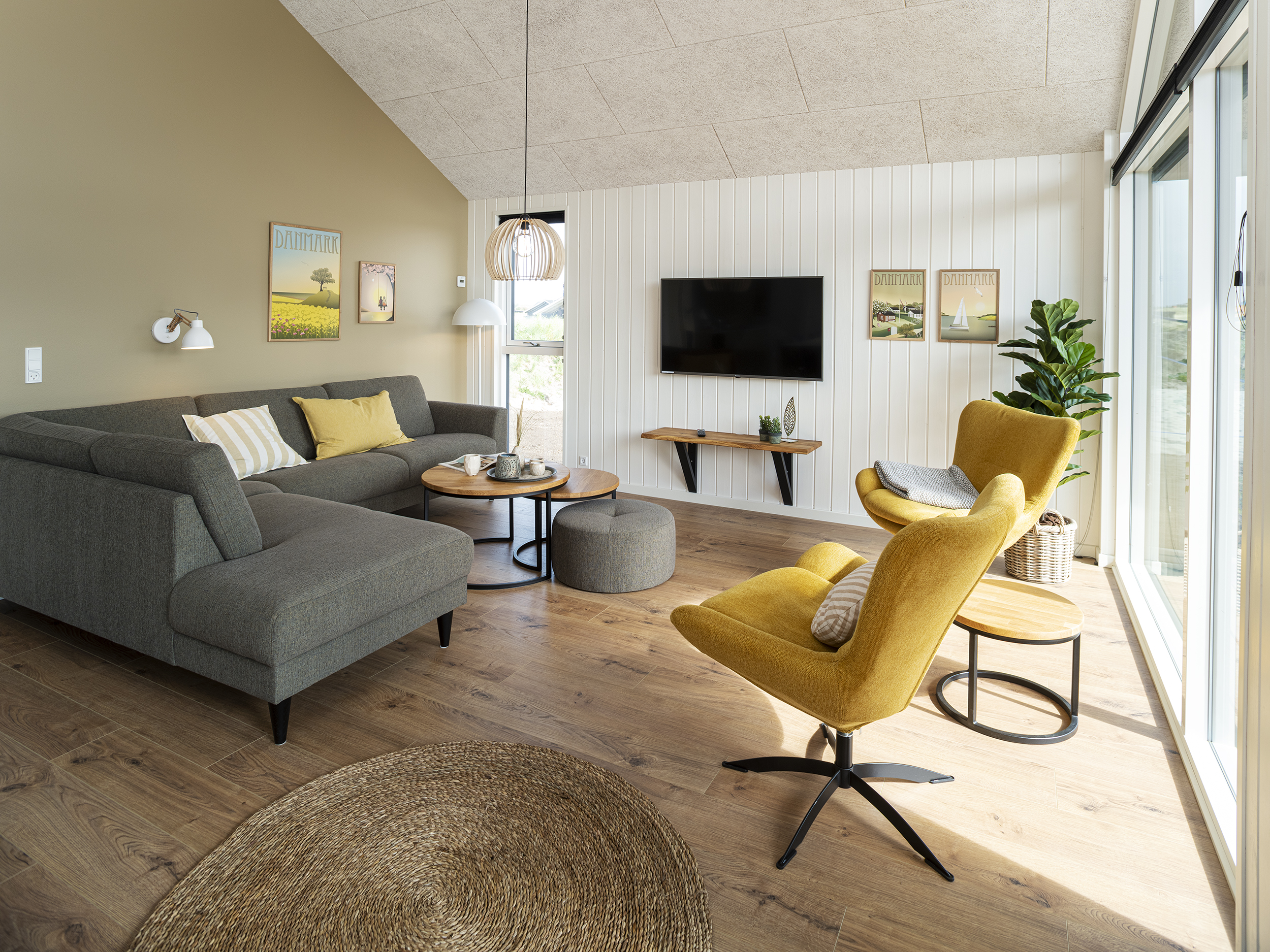 Stue i sommerhus med trægulv og grøn væg