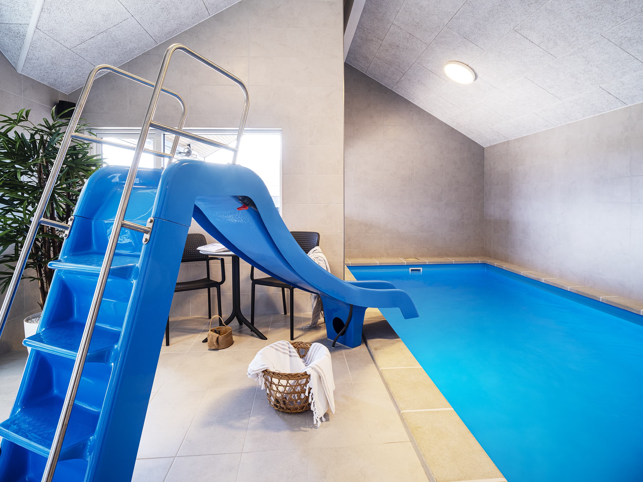 Indendørs pool med rutsjebane i lyst rum