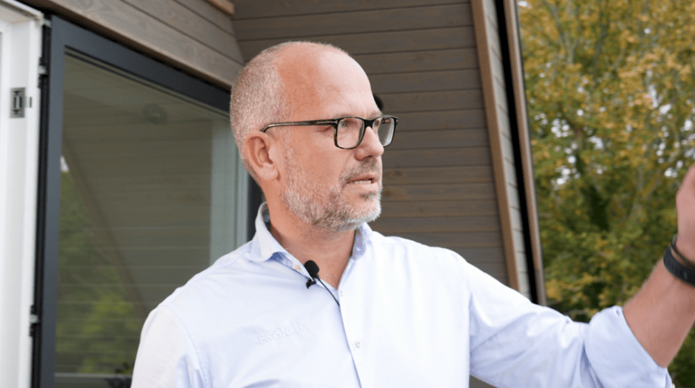 Søren Milo gestikulerer foran sommerhus