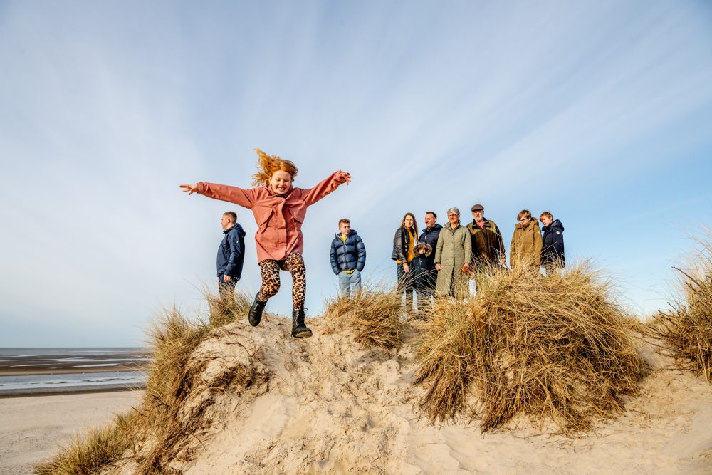 Familie på gåtur i klitter nær strand