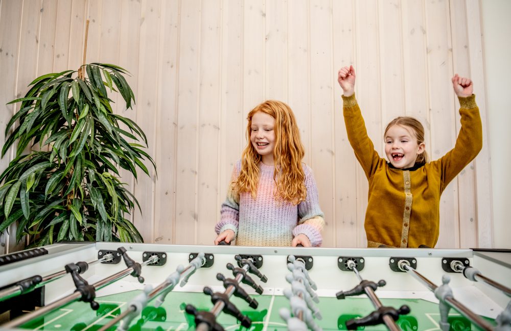 Glade børn spiller bordfodbold