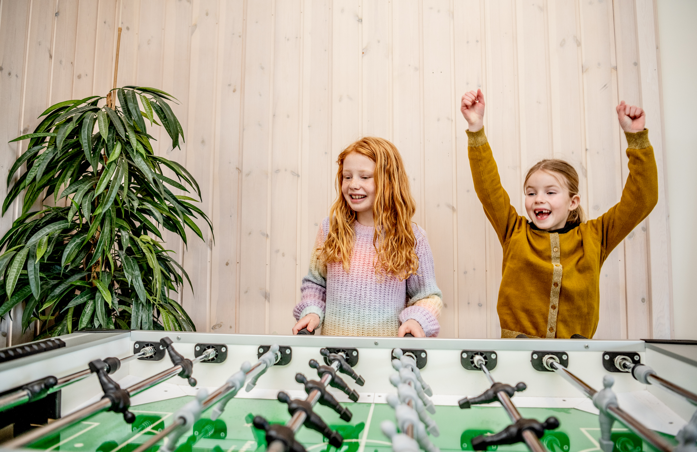 Glade børn spiller bordfodbold