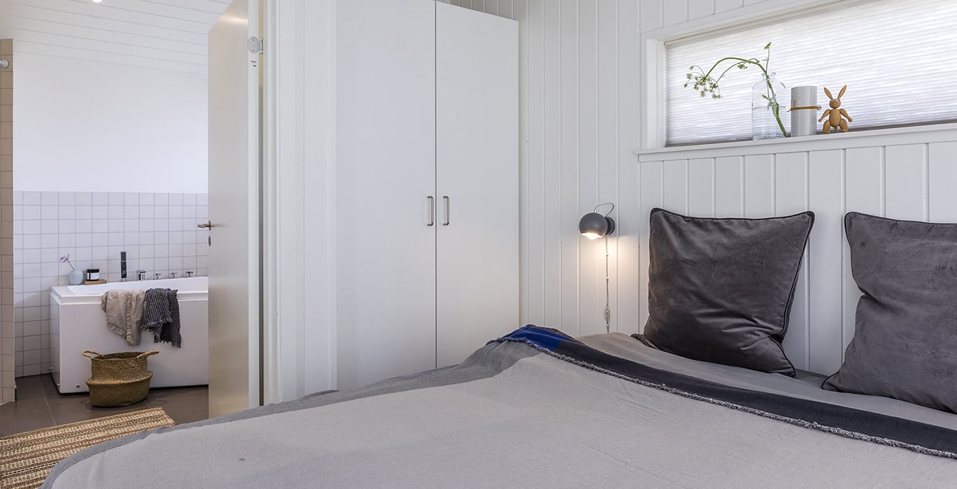 Stilrent soveværelse med kig til badeværelse