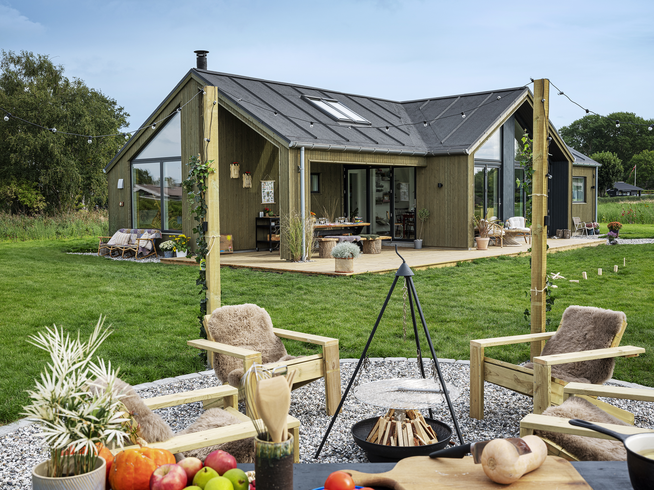 Sommerhus med bålsted i forgrunden