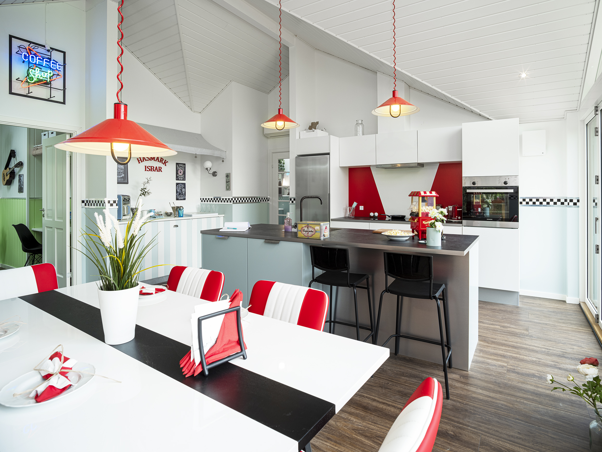 Køkken med røde stole og røde lamper
