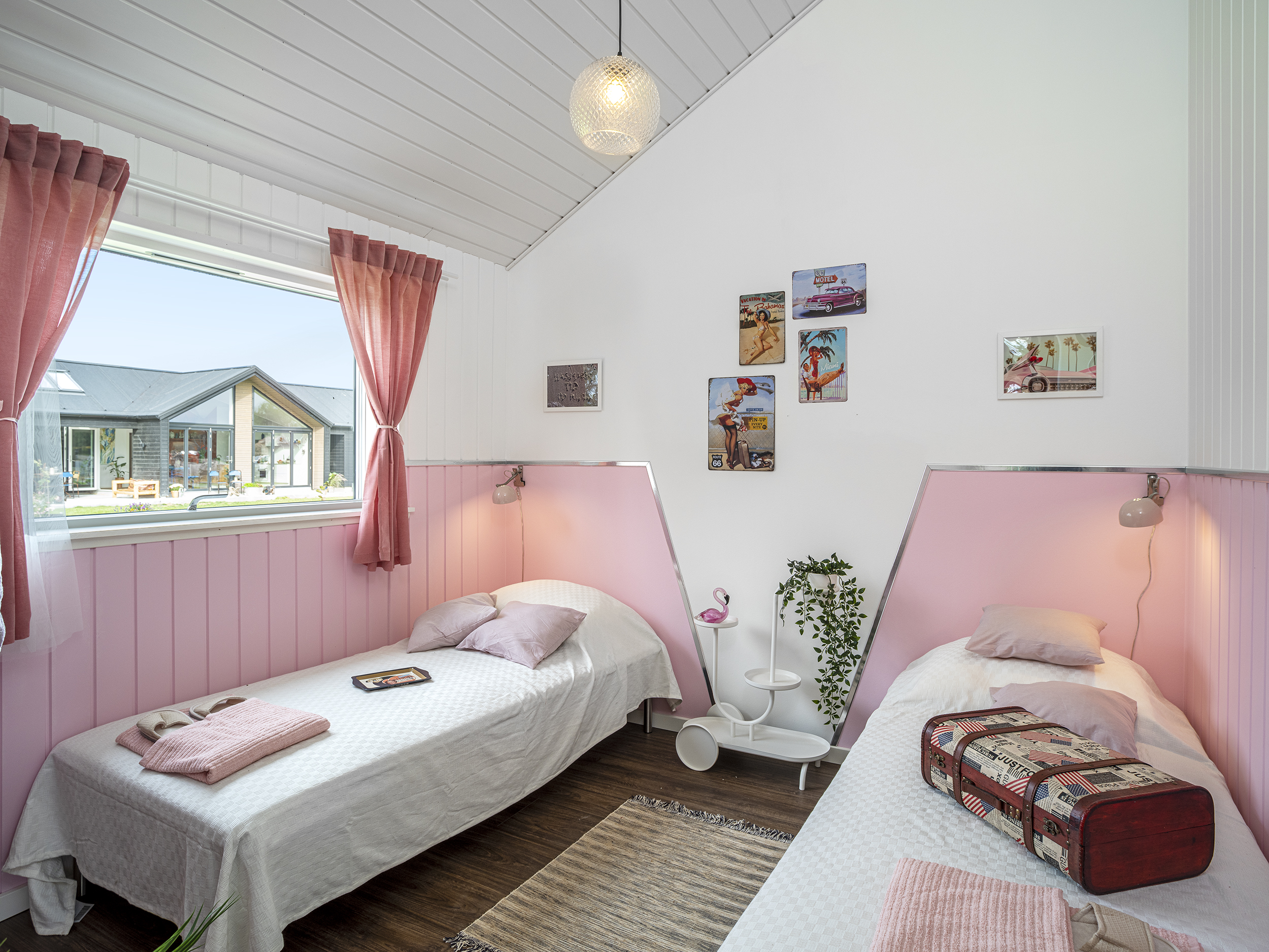 Lyserødt værelse med to enkeltsenge