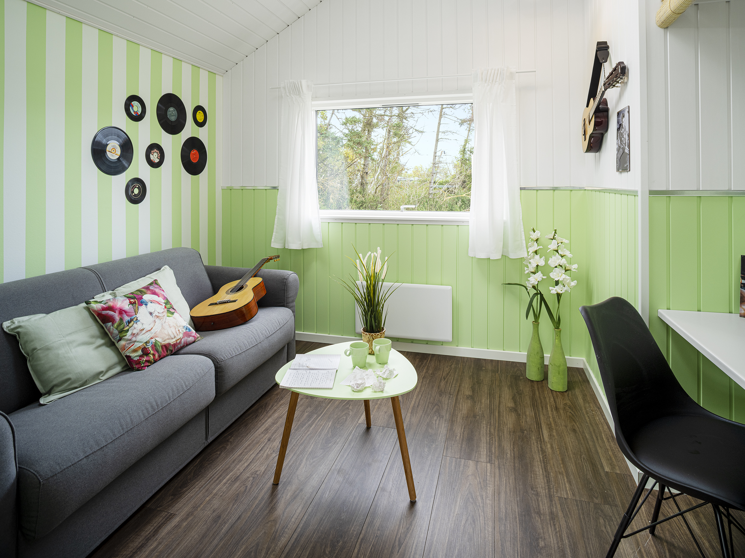 Værelse med sofa og grønne træbeklædte vægge