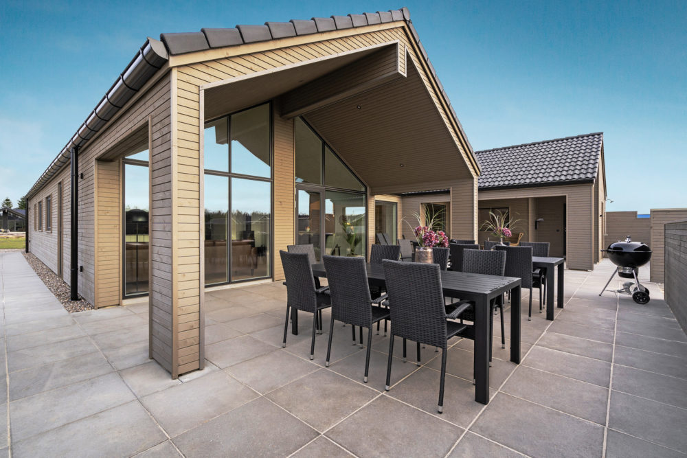 Træhus fra skanlux sommerhus set fra hyggelig terrasse med overdækning