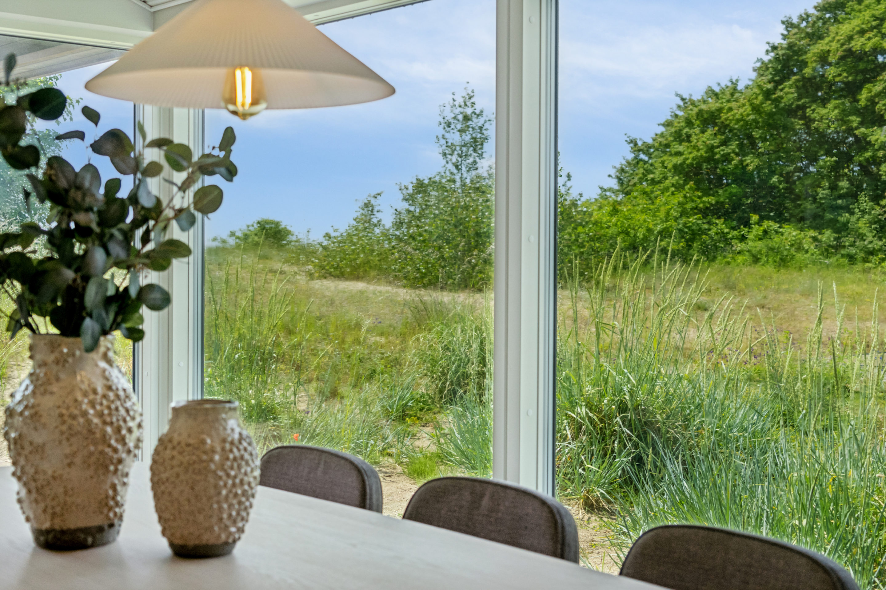 Close up af spisebord med kig til udendørsarealer