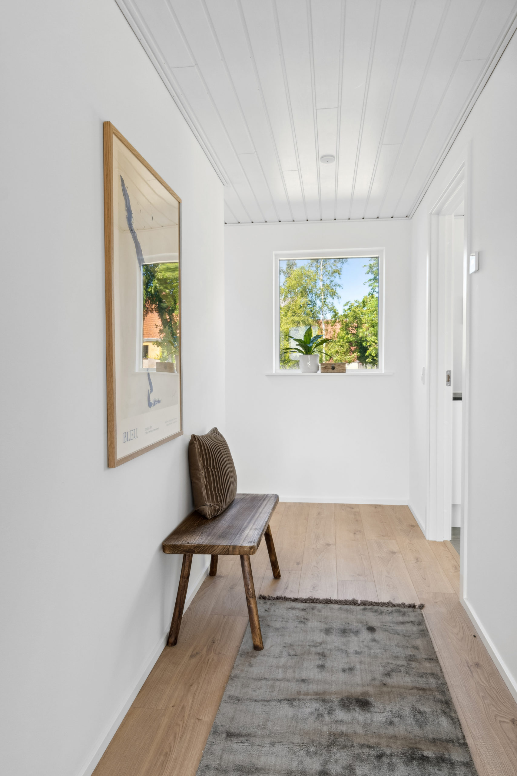 Gang med trægulv og bænk