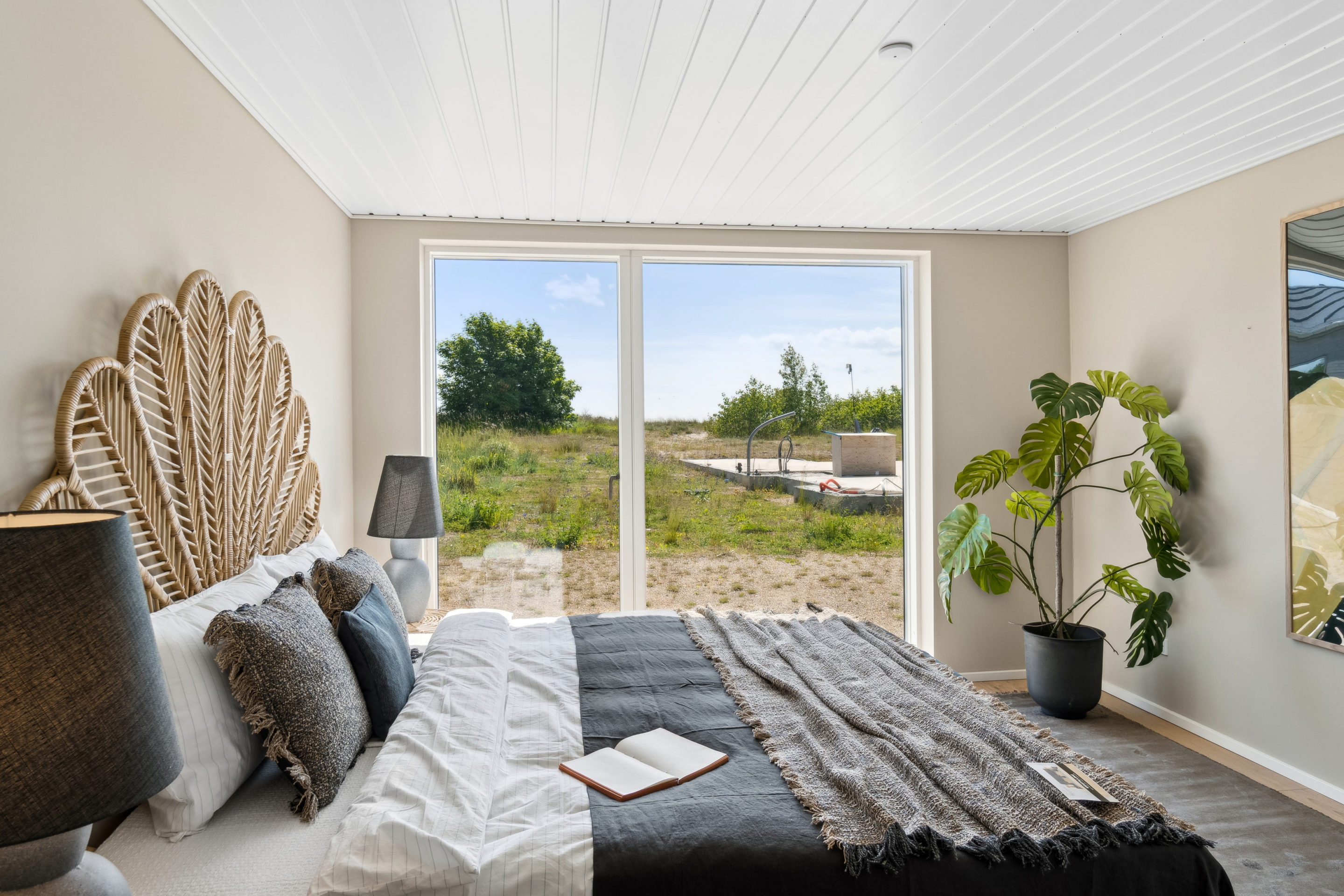 Soveværelse i nybygget sommerhus med kig til vand