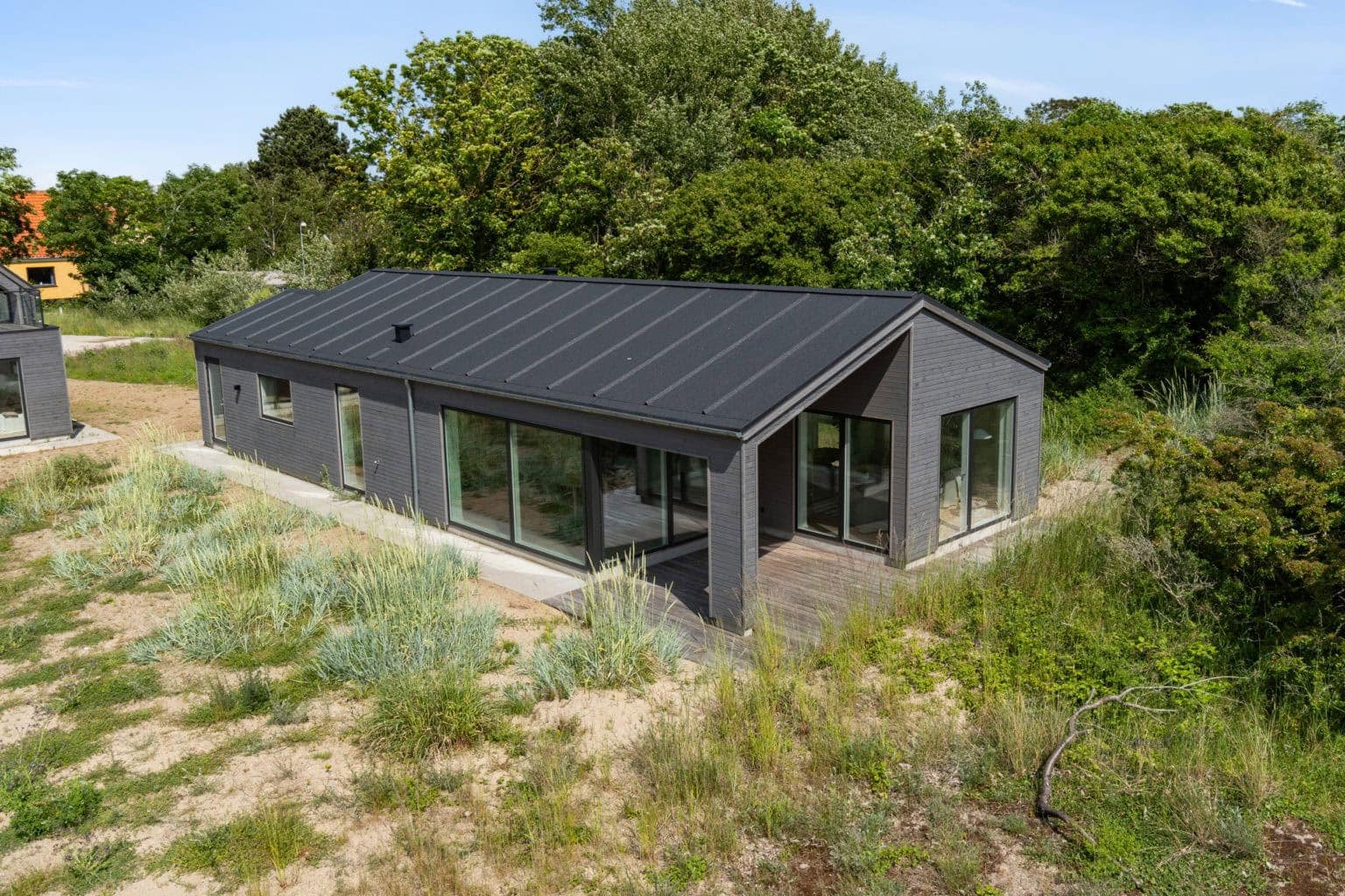 Sort sommerhus med tagpap set udefra